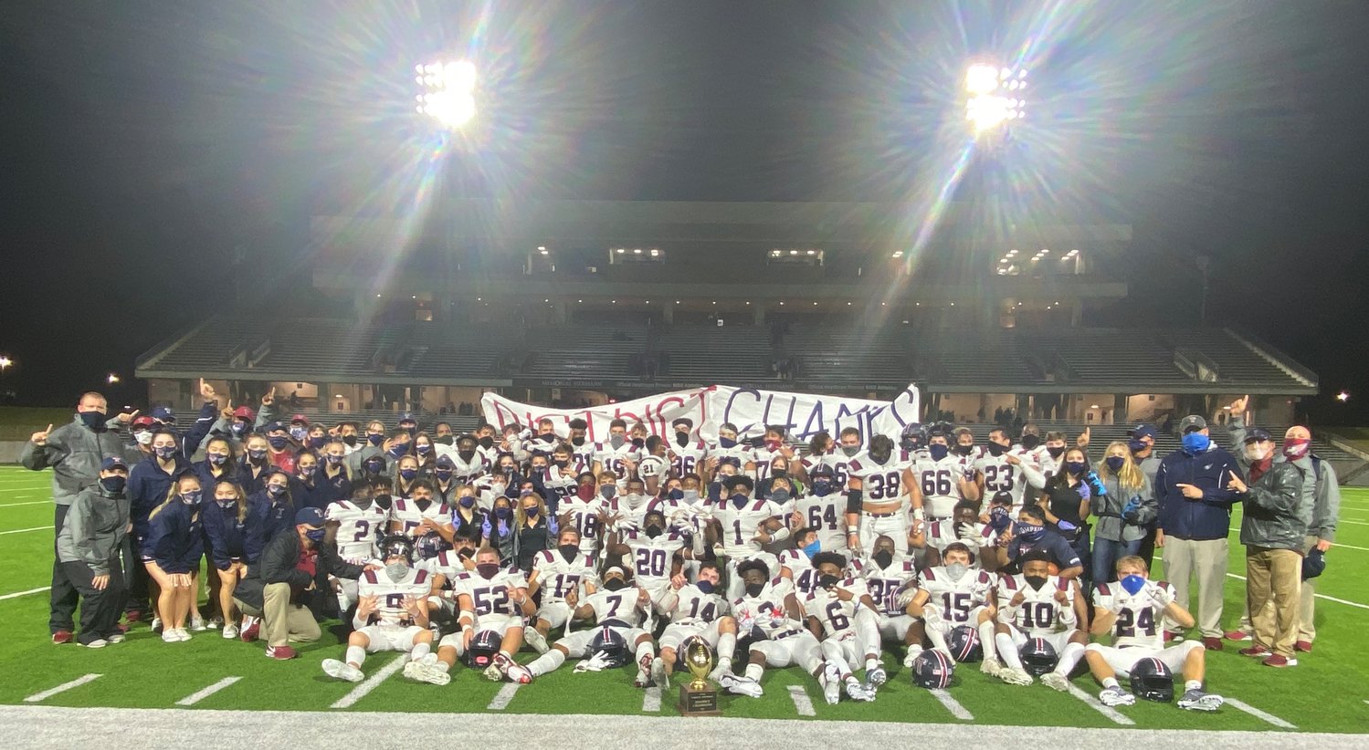 Tompkins football coaches, players and support staff celebrate and pose for a photo following their win over Seven Lakes on Nov. 27.